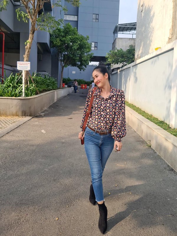 Quỳnh Lam hóa thân thành cô nàng công sở thanh lịch, hiện đại trong set đồ áo sơ mi họa tiết và quần jeans xanh. (Ảnh: FB Hoàng Quỳnh Lam)