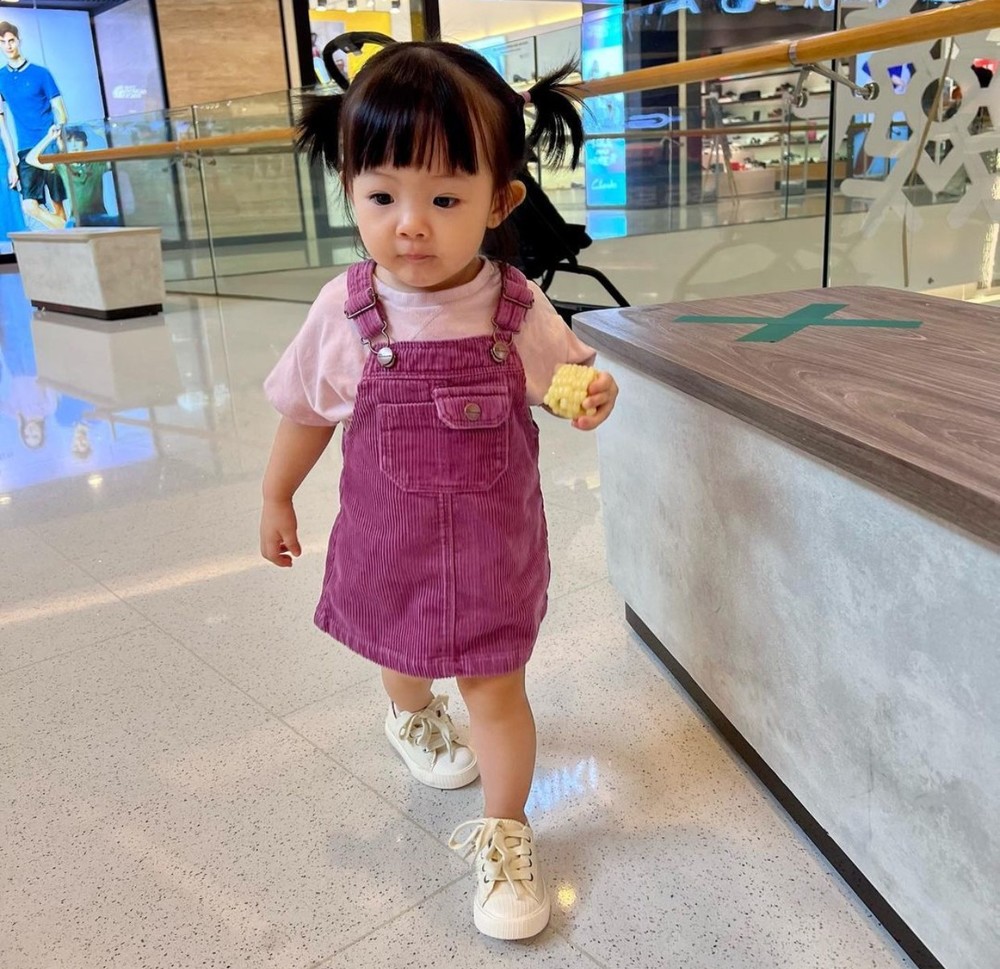 Suchin cute lạc lối trong chiếc váy yếm màu tím được mẹ phối tông xuyệt tông với áo thun bên trong. (Ảnh: Instagram suchin_baby)