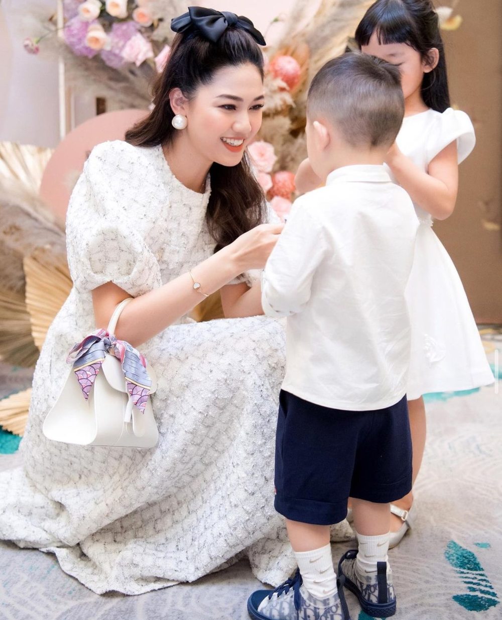 Trước đó khi dự tiệc gia đình, người đẹp cũng đeo một mẫu túi hiệu dù bận chăm sóc con. (Ảnh: Instagram tttu.ngo)