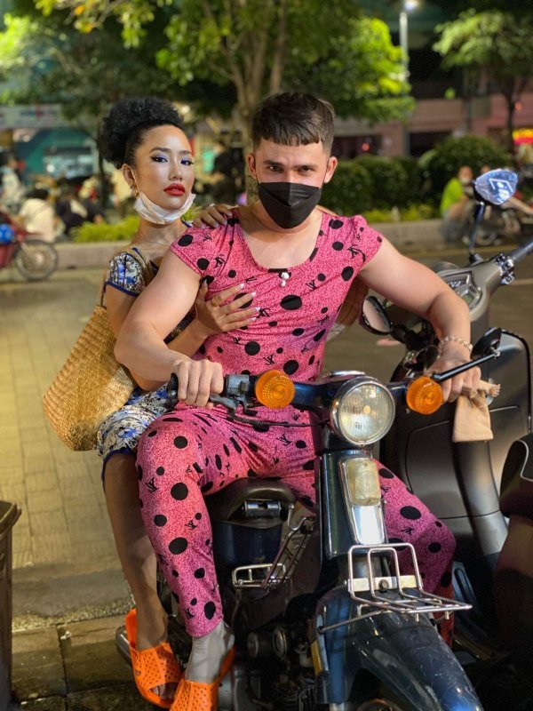 Cặp đôi không quên mang thêm đôi dép tổ ong cam neon để hoàn thiện hơn outfit đậm chất Việt Nam. (Ảnh: FB Phạm Vy)